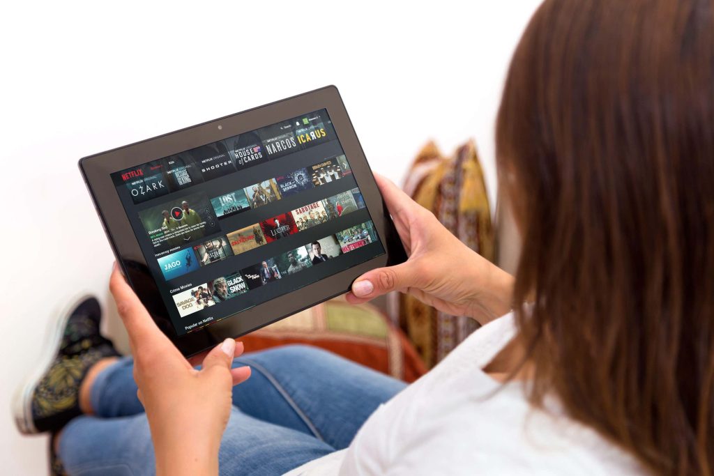 A woman watching Netflix on a tablet