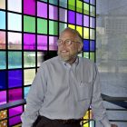 FILE - Co-founder and retired CEO of Adobe Systems Inc. John Warnock stands next to a window of color panes that represent the color swatches in their program PhotoShop at Adobe headquarters in San Jose, Calif., May 9, 2001. Warnock, the inventor of the PDF and Adobe Systems co-founder died Saturday, Aug. 19, 2023, the software company said. (AP Photo/Paul Sakuma, File)