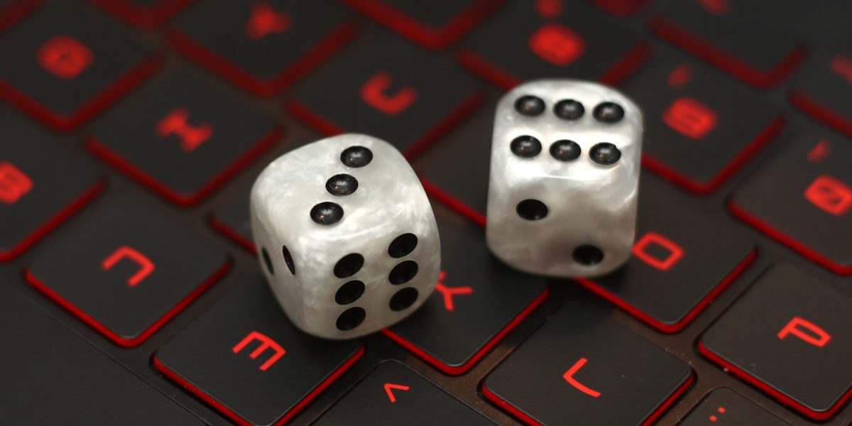 Dice on a laptop keyboard. Photo credit should read: Tim Goode/PA Wire.