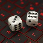 Dice on a laptop keyboard. Photo credit should read: Tim Goode/PA Wire.